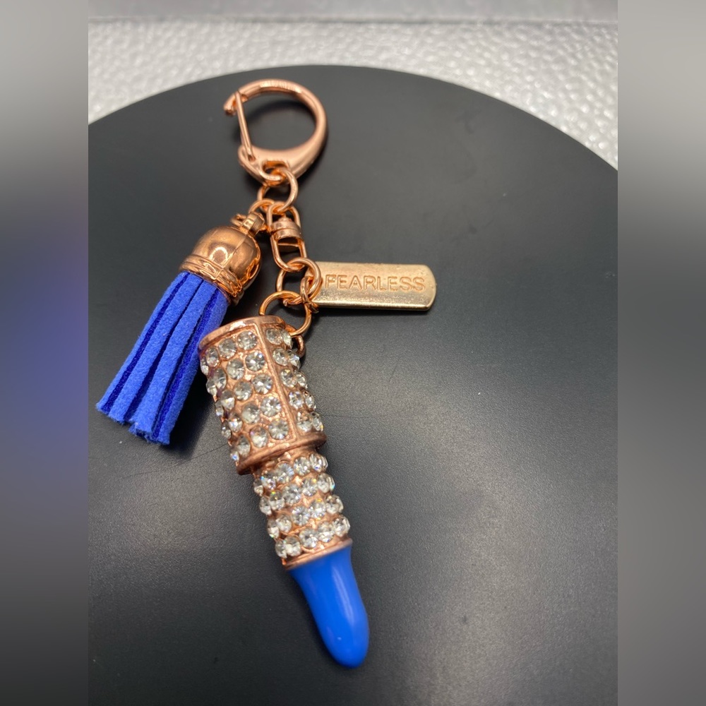 Dark blue lipstick rose gold tone keychain with a tag that says fearless